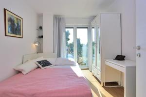 a bedroom with a bed and a desk and a window at Karmen Adriatica in Kukljica +40 photos