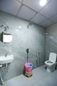 a bathroom with a sink and a toilet and a mirror at HOTEL GREEN VILLA in Surat