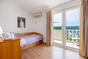 a bedroom with a bed and a sliding glass door at Studio APARTMANI LEŽENIĆ in Neum
