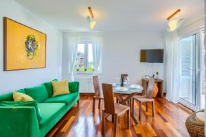 Una sala de estar con un sofá verde y una mesa. en Kos, en Murter