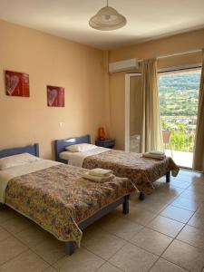 Habitación de hotel con 2 camas y ventana en Myrtos Hotel, en Divarata