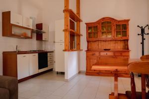 a kitchen with a wooden cabinet and a table at Il Vecchio Pozzo in Porto Ottiolu