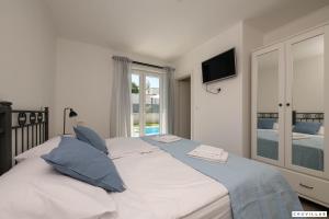 a bedroom with a large white bed with blue pillows at Lavanda-labin in Veli Turini +40 photos