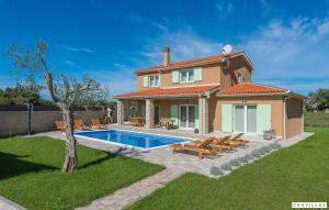 una villa con piscina di fronte a una casa di Matea a Marčana