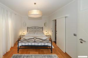 a bedroom with a bed and a chandelier at Monty in Pridraga +34 photos