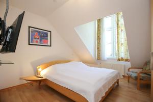 ein Schlafzimmer mit einem Bett, einem Stuhl und einem Fenster in der Unterkunft Sünnslag Wohnung 148 in Boltenhagen