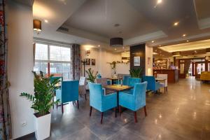 a restaurant with blue chairs and tables in a room at Willa Kmicic in Zakopane