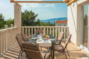 a patio with a table and chairs on a balcony at Milla Hvar in Rudina