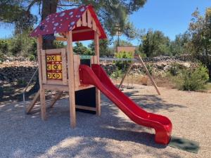 a playground with a red slide and a swing at Milla Hvar in Rudina