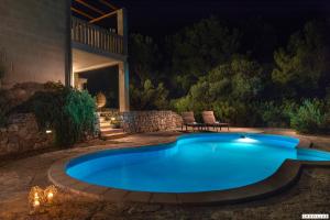 a swimming pool in a backyard at night at Milla Hvar in Rudina