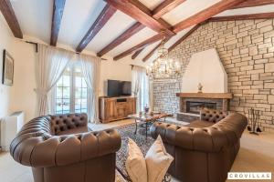 een woonkamer met lederen meubels en een open haard bij Mek in Pridraga