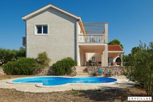 a villa with a swimming pool in front of a house at Nella Hvar in Rudina