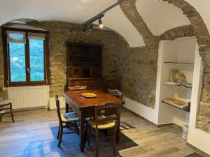 多爾恰夸的住宿－Gli Orti dei Doria di dolceacqua，一间带木桌和椅子的用餐室