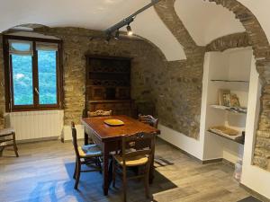 a dining room with a wooden table and chairs at Gli Orti dei Doria di dolceacqua in Dolceacqua