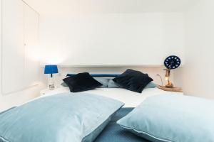 a bedroom with two beds with blue pillows at Sea Loft Quinto - A due passi dal mare in Genoa