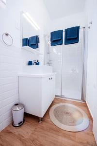 ein Badezimmer mit einem weißen Waschbecken und einer Dusche in der Unterkunft Muntan in Kraj + 59 Fotos