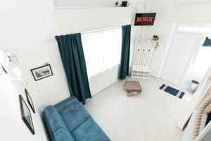 a living room with a blue couch and a window at Sea Loft Quinto - A due passi dal mare in Genoa