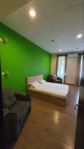 a green room with a bed and a couch at Your Home Hotel in Tbilisi City