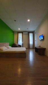a large room with a bed and a flat screen tv at Your Home Hotel in Tbilisi City
