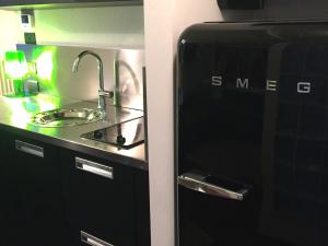 a kitchen with a sink next to a refrigerator at BASTIA RF Suite up to 4 guests - in the heart of Scalo Romana, Olimpico, Prada, Bocconi and easy access Forum Assago, IEO, IED, Duomo, San Siro in Milan