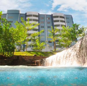 uma queda de água em frente a um edifício com uma cascata em IMG Hotel Rio Quente em Rio Quente