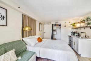um pequeno quarto com uma cama e uma cozinha em Bright & Cozy Condo Unit with Balcony! em Honolulu