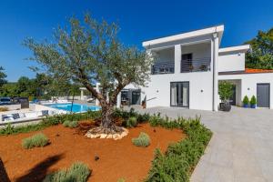a white house with a tree in front of it at Valhalla in Barat