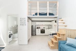 a living room with a blue couch and a kitchen at Sea Loft Quinto - A due passi dal mare in Genoa