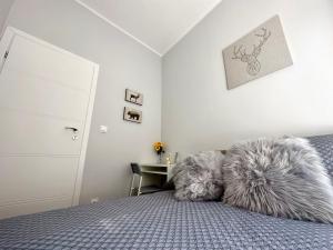 a bedroom with a bed with two furry pillows on it at MMRent Wild Room in Gdańsk