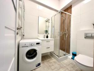 a white bathroom with a washing machine and a sink at MMRent Wild Room in Gdańsk