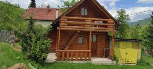 a log cabin with a yellow garage in front of it at Velemun brvnara in Plav