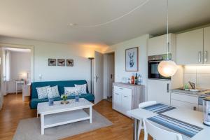 a living room with a blue couch and a table at Merzel's schöne Aussicht in Bühlertal