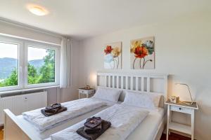ビューラータールにあるMerzel's schöne Aussichtの白いベッドルーム(ベッド2台、窓2つ付)が備わります。