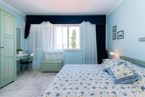 a bedroom with a bed and a desk and a window at Apartments Rada i Stanislav in Barbat na Rabu