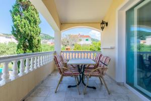 a patio with a table and chairs on a balcony at Apartments Rada i Stanislav in Barbat na Rabu