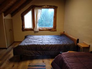 a bedroom with a bed and a window at El viaje 2 in San Carlos de Bariloche