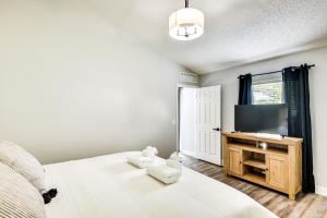 a bedroom with a bed and a flat screen tv at Palm Coast Vacation Rental about 8 Mi to Flagler Beach in Flagler Beach