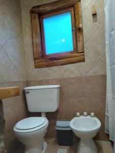 a bathroom with a toilet and a window at El viaje 2 in San Carlos de Bariloche