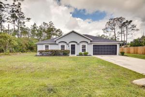 a white house with a garage at Palm Coast Vacation Rental about 8 Mi to Flagler Beach in Flagler Beach