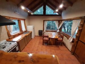 a kitchen with a stove and a table with chairs at El viaje 2 in San Carlos de Bariloche