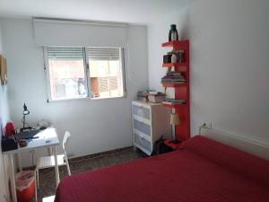 sypialnia z łóżkiem, biurkiem i oknem w obiekcie PISO 4 HABITACIONES BURJASOT w mieście Burjasot