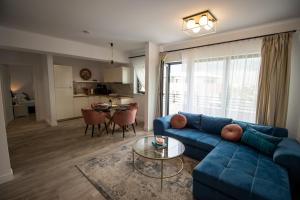 a living room with a blue couch and a table at The CLOCK in Voluntari