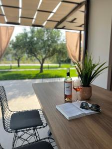 a table with a bottle of wine and a glass at Naiades Villas Aigli in Ladharió