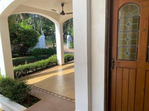 una entrada a una casa con puerta de madera en 1BHK Luxury Homestay In Betalbatim, South Goa en Marmagao