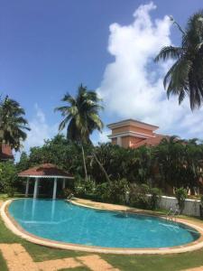 una piscina con cenador y palmeras en 1BHK Luxury Homestay In Betalbatim, South Goa en Marmagao