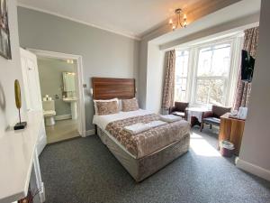 1 dormitorio con 1 cama grande y sala de estar en The Broadway Hotel, en Llandudno
