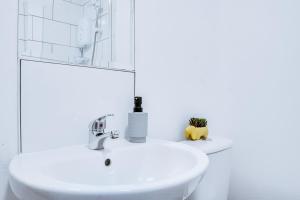 a white bathroom with a sink and a mirror at Birkenhead - 2 bedroom house in Birkenhead