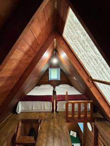 an attic room with a bed and two windows at HOTEL CERVECERIA JAMES in Xilitla