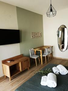 a living room with a television and a table with chairs at ROUTE DU CANAL in Nea Roda