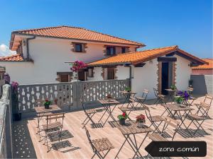 un patio con sillas y mesas frente a una casa en La Maruca Beach Santander, en Santander